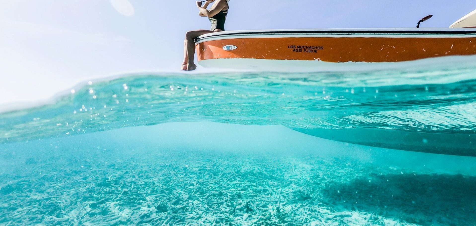 A person enjoys leisure on a boat in the clear waters of Dependencias Federales, Venezuela.